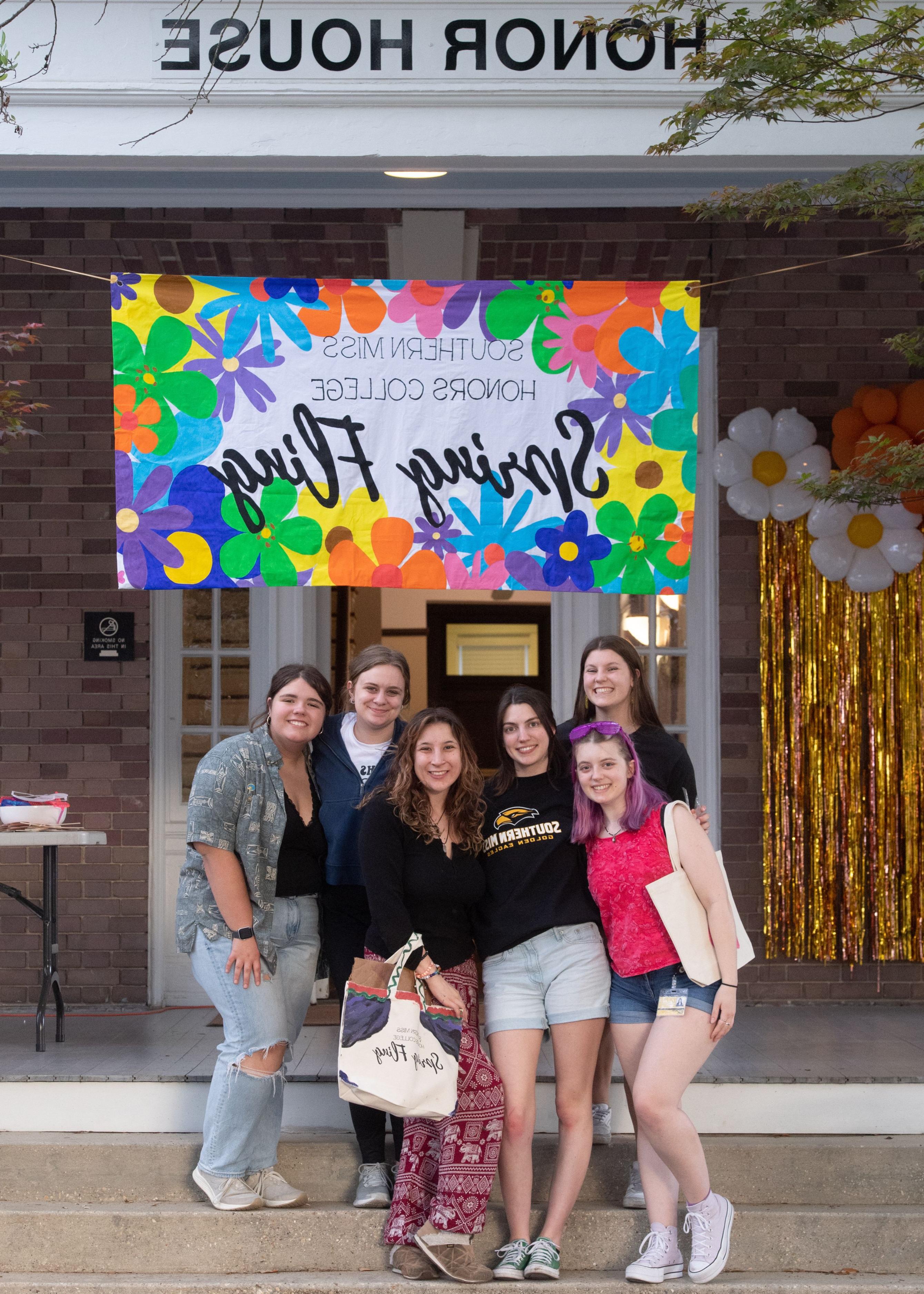 Honors students standing in front of the Honor House at Spring Fling